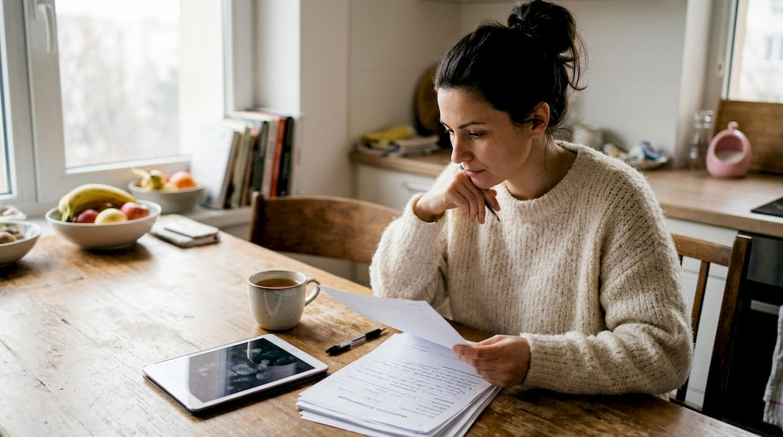 Жена разглежда медицинските си документи на кухненската маса.